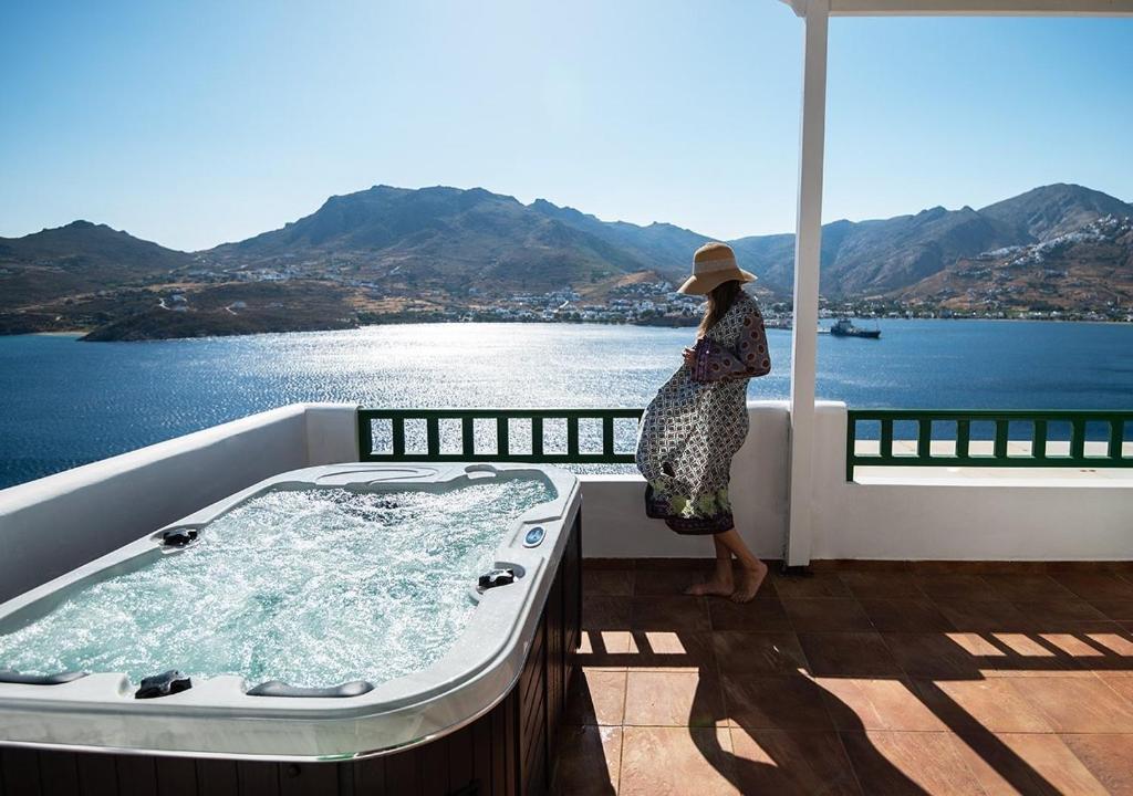 a woman standing in a bath tub on a balcony at Astrio Suites in Livadi