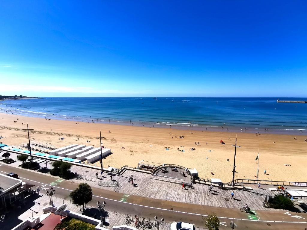 a view of a beach with people in the water at Le Foch - Appartement face mer avec garage in Les Sables-d'Olonne