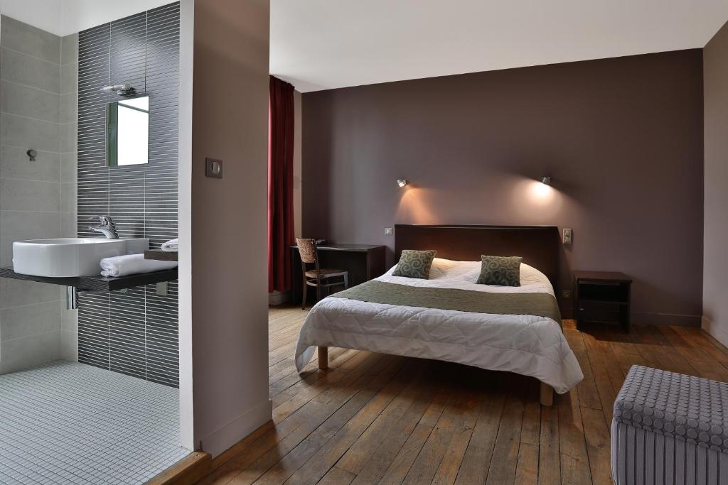 - une chambre avec un lit et une salle de bains pourvue d'un lavabo dans l'établissement Le Coligny, à Brantôme