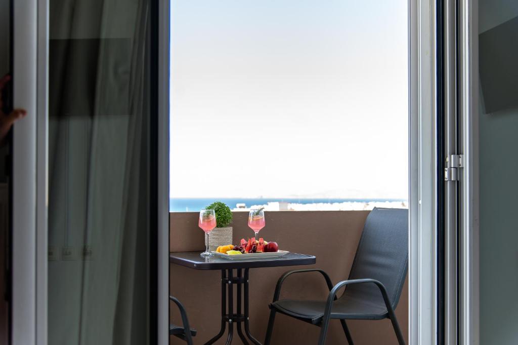 een kleine tafel met fruit en drankjes voor een raam bij Haris apartment 2 in Heraklion