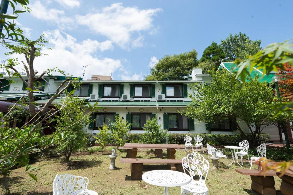 una mesa de picnic y sillas frente a un edificio en Pension Yufuin, en Yufu