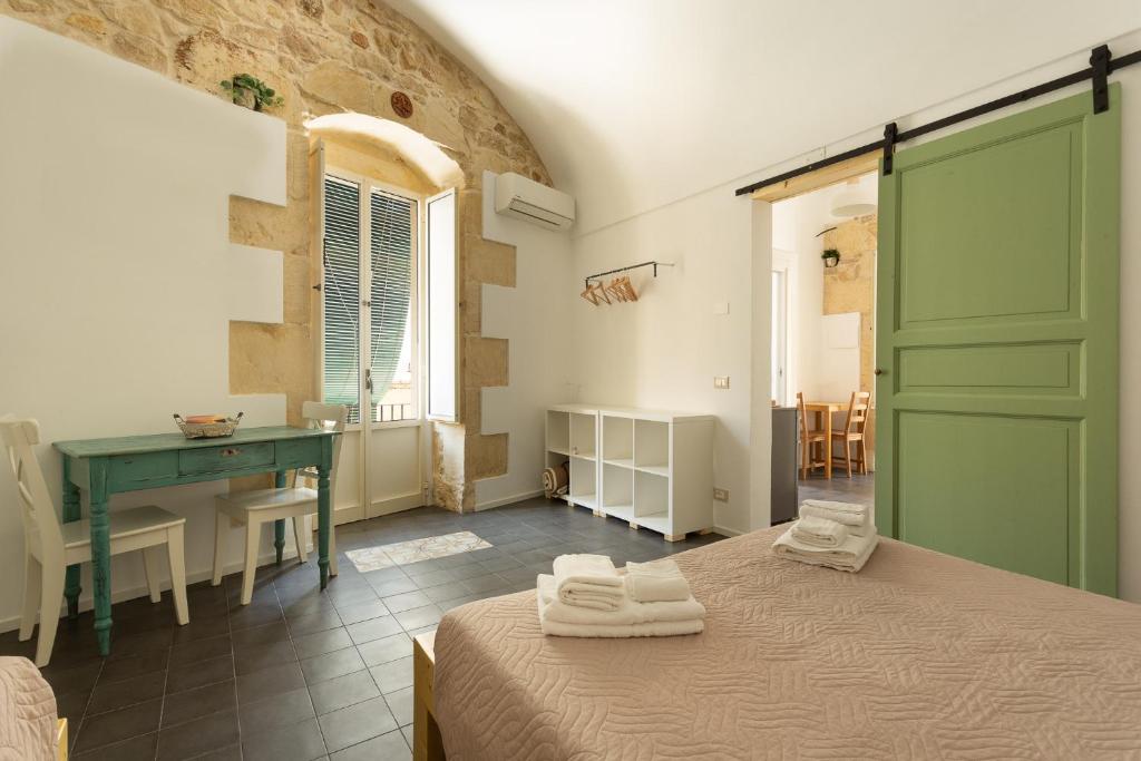 a bedroom with a bed and a desk and a table at Pura Vida Barocca in Ragusa