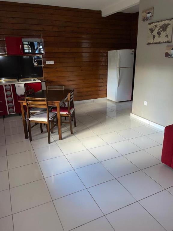 a kitchen with a table and a refrigerator at Balisier in Vieux Bourg