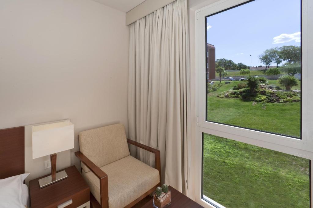 a room with a chair and a large window at Hotel Albatros Plava Laguna in Poreč