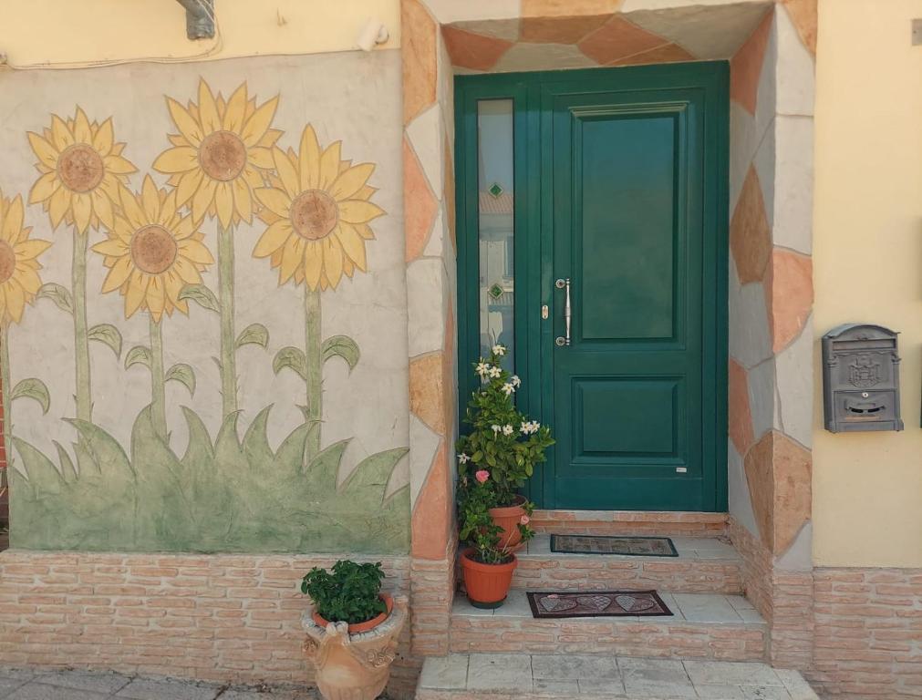 庫佩洛的住宿－Casa Vacanze e B&B In Piazza，墙上花朵的绿色门