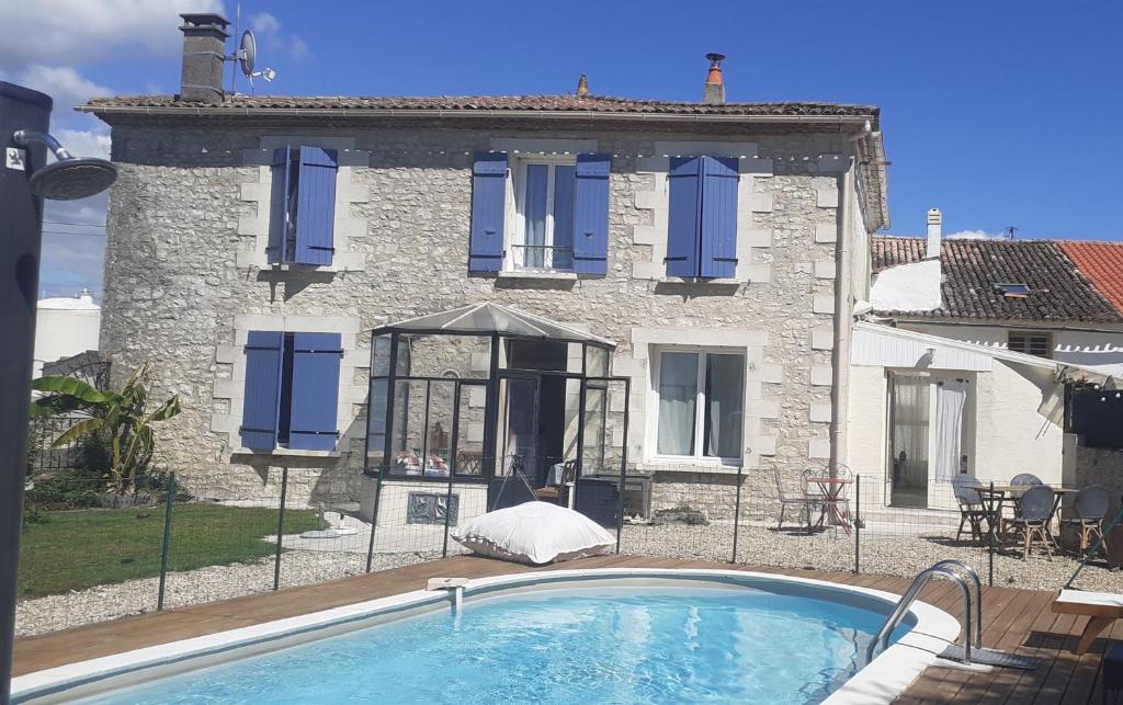 a house with a swimming pool in front of a building at Les Flots De Ma Vie Chambres D Hotes et tipi Florence Et Virginie Gossin in Barzan