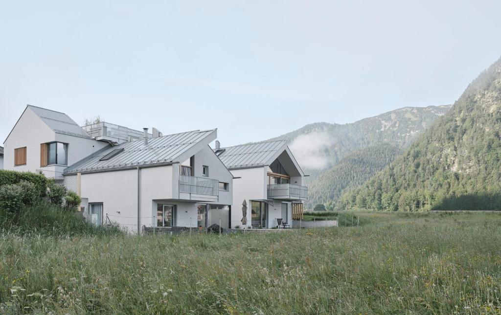a house in a field with mountains in the background at Urban Mountain Chalet with Lake View in Maurach