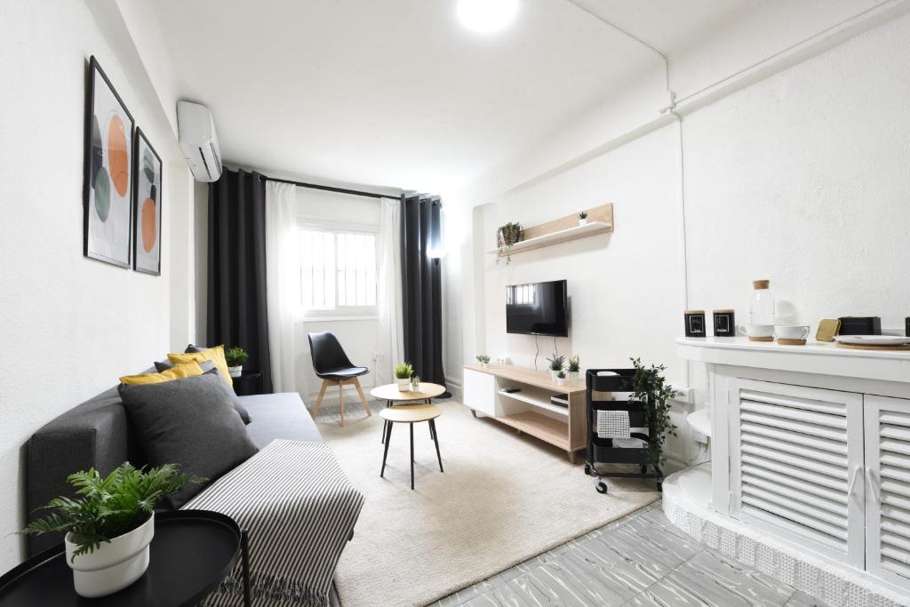 Sala de estar blanca con sofá y mesa en Nordik Apartments Village - Arroyo "Rovaniemi" en Benalmádena