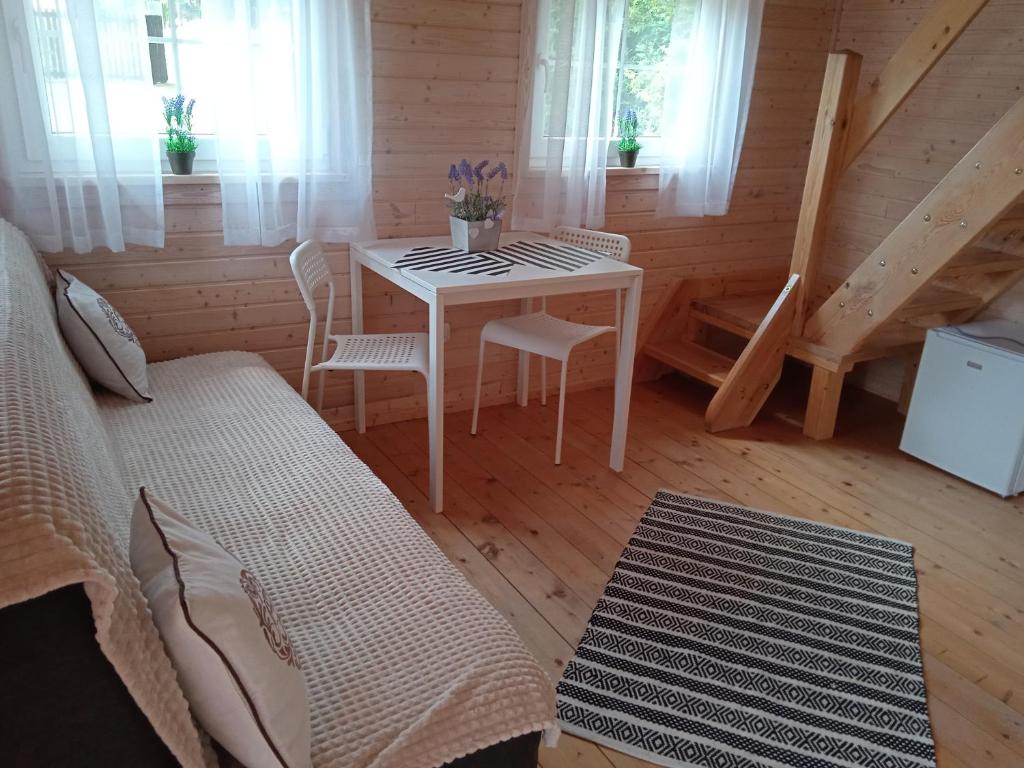 a room with a table and chairs in a cabin at Domek Letniskowy "Domek Lawendowy" in Pisz