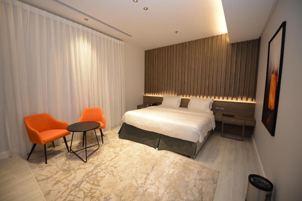 a hotel room with a bed and a table and chairs at WDF Serviecd Apartment in Jeddah