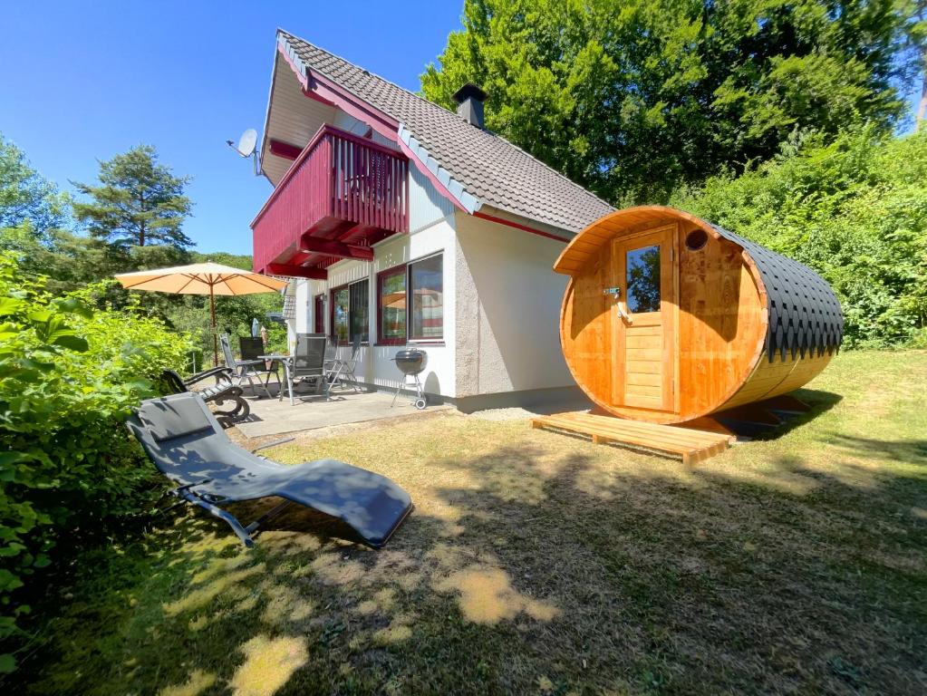 a house with a large wooden door and a chair at Entspannung in der Natur mit Seeblick und Sauna - Ferienhaus Felix von Mein-Seepark in Kirchheim