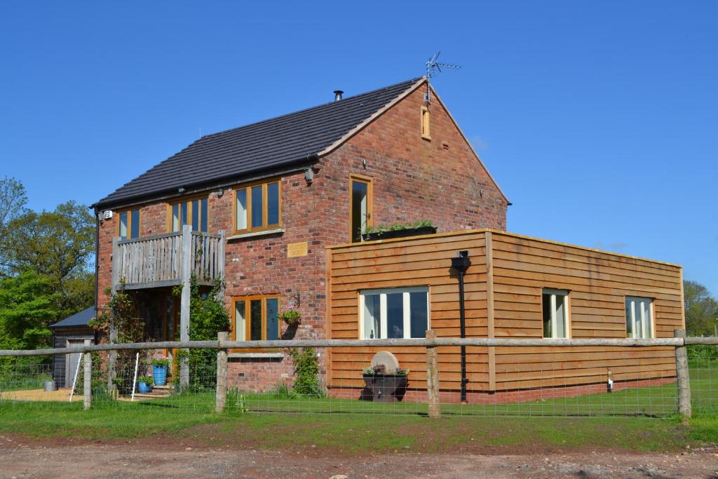a large brick house with a deck on top of it at Mutton Barn in Alcester