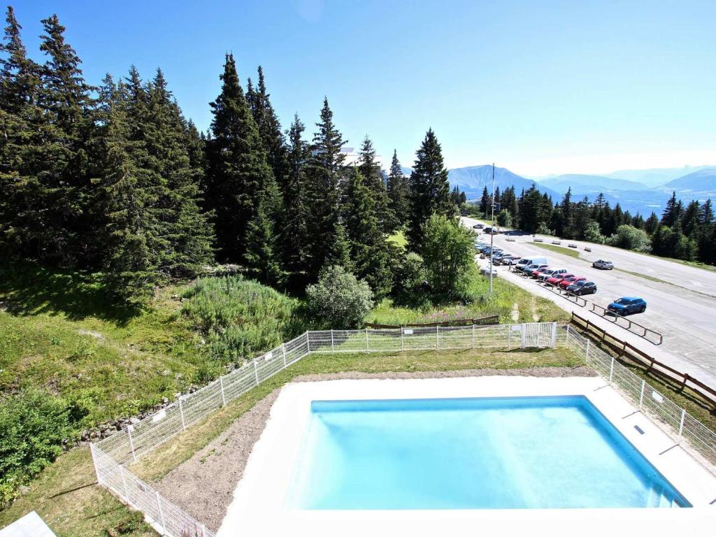 ein Schwimmbad auf einem Hügel neben einer Autobahn in der Unterkunft Studio Chamrousse, 1 pièce, 4 personnes - FR-1-549-38 in Chamrousse