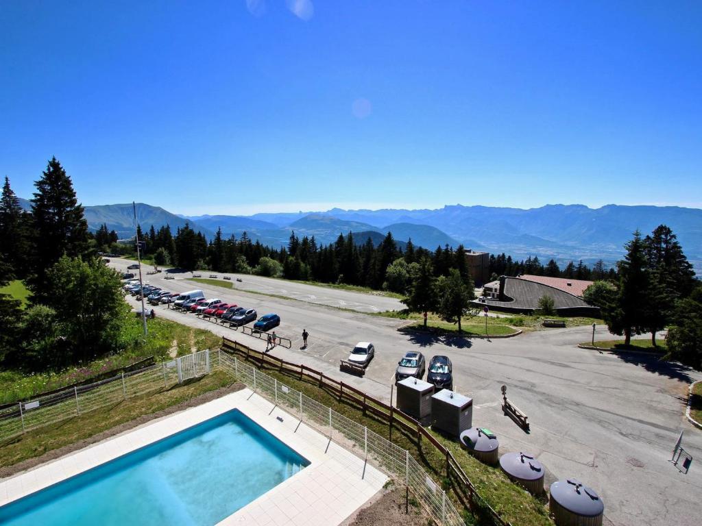 a swimming pool next to a parking lot with cars at Studio Chamrousse, 1 pièce, 4 personnes - FR-1-549-33 in Chamrousse