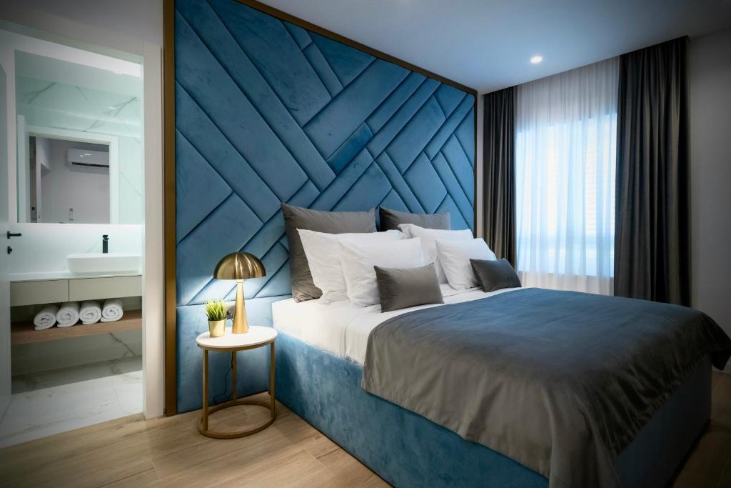 een slaapkamer met een groot bed met een blauw hoofdeinde bij Amélie Luxury Rooms in Split