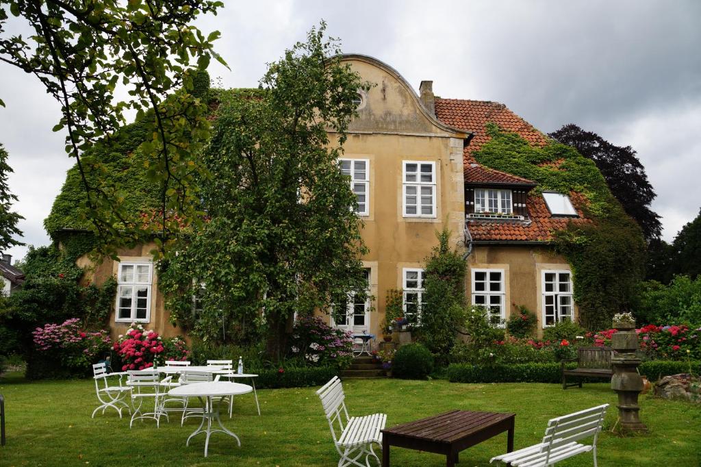 a house with tables and chairs in front of it at Haus Kroneck-Salis Gästeappartement in Bad Iburg
