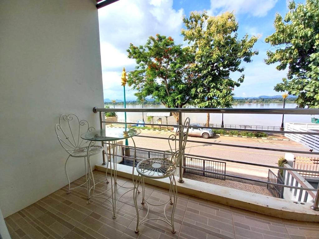 balcón con mesa y sillas y vistas a la calle en บ้านเลียบโขง@นครพนม en Ban Nong Puk