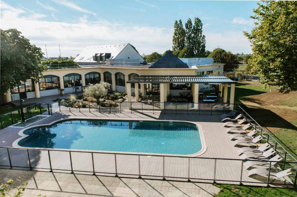 an overhead view of a swimming pool in front of a house at Hotel Le Paddock in Magny-Cours