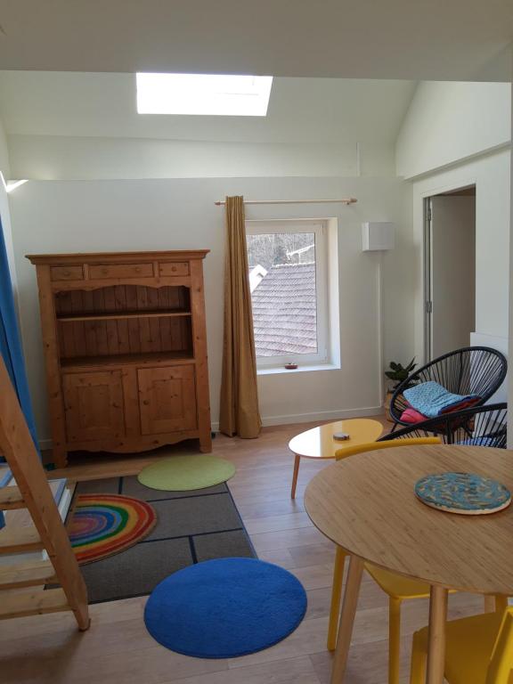 a living room with a table and chairs and a window at Studio calme et lumineux avec terrasse in Auxelles-Haut