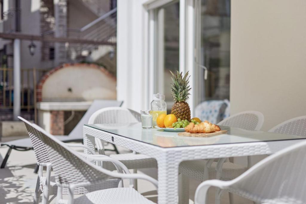 a plate of fruit on a white table on a patio at Petrovic apartmani in Tivat