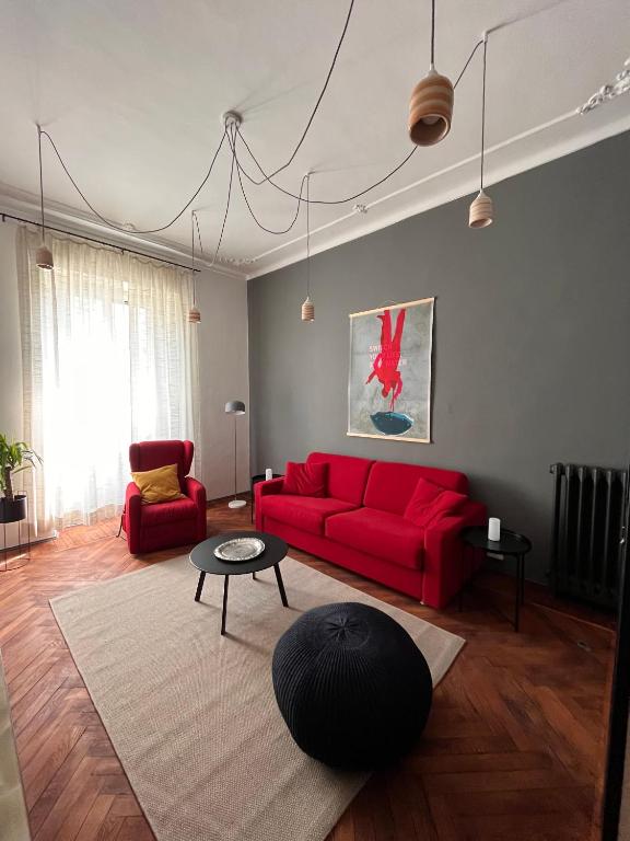 sala de estar con sofá rojo y mesa en Elegante e accogliente appartamento a Torino, en Turín