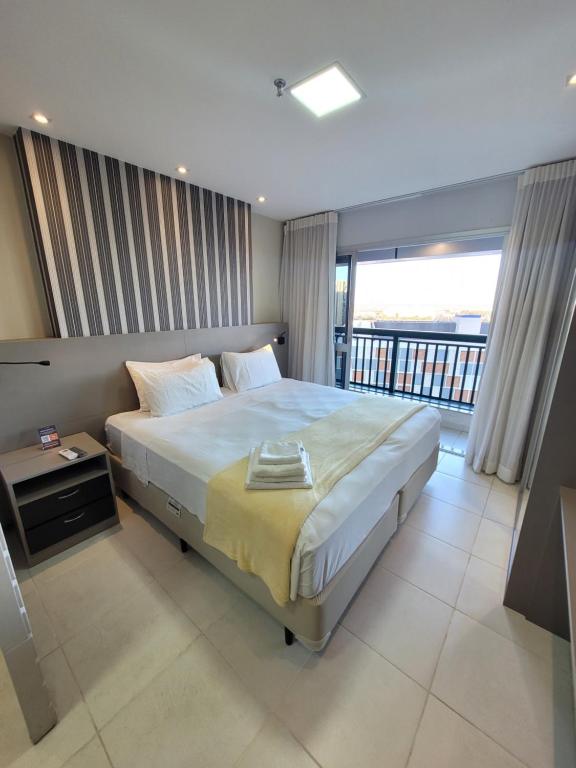 a bedroom with a large bed and a balcony at Vision Executive Esplanada in Brasilia