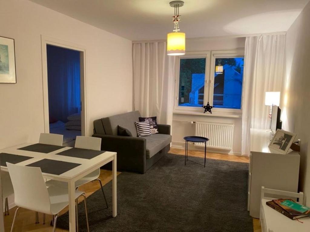 een woonkamer met een bank en een tafel bij Ljus in Sopot