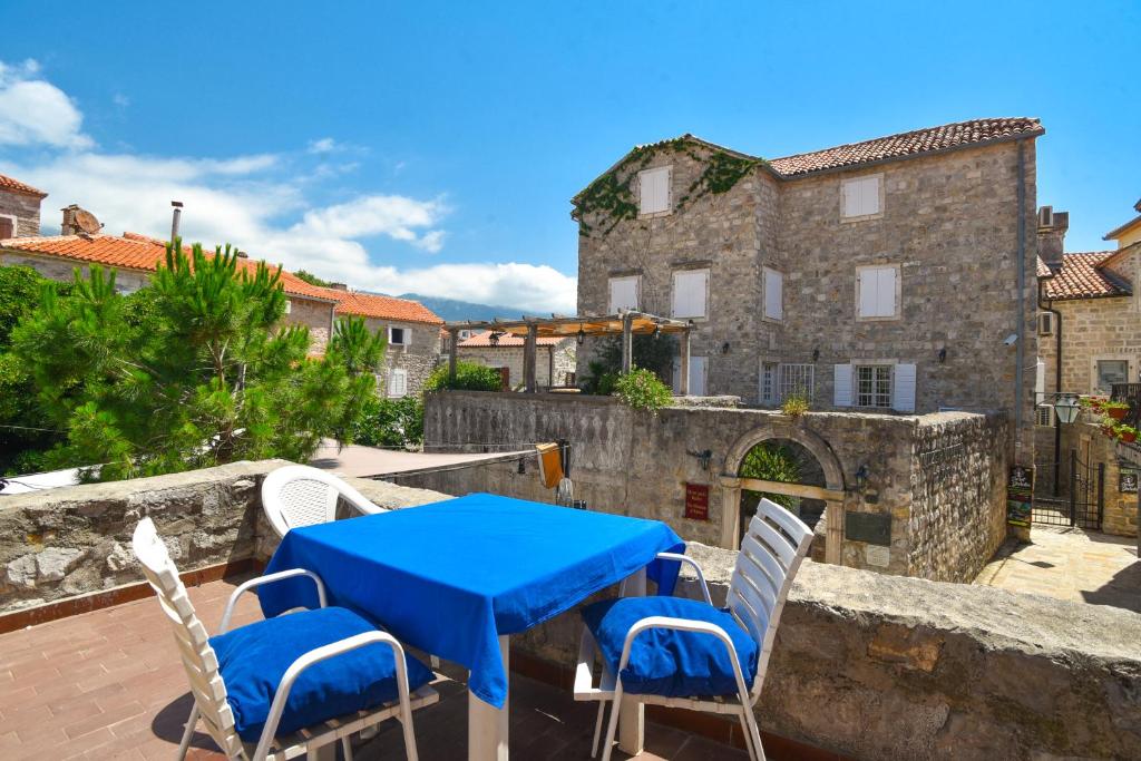 a blue table and chairs on a patio with a building at Apartment Lucky in Budva