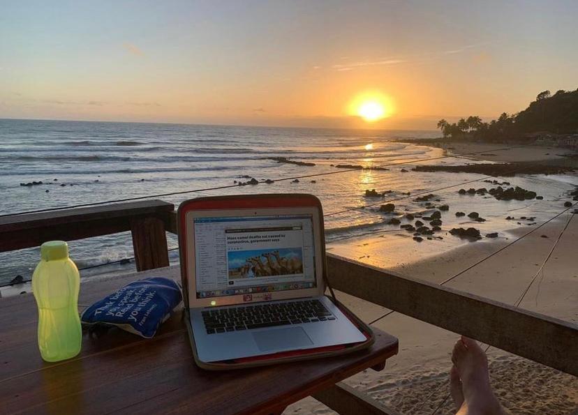 a laptop computer sitting on a picnic table on a beach at Pé na Areia in Baía Formosa