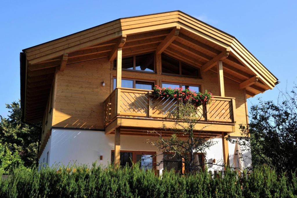 a house with a balcony with flowers on it at Chalet Mandl Sauna Pool Rollstuhlgängig in Maishofen