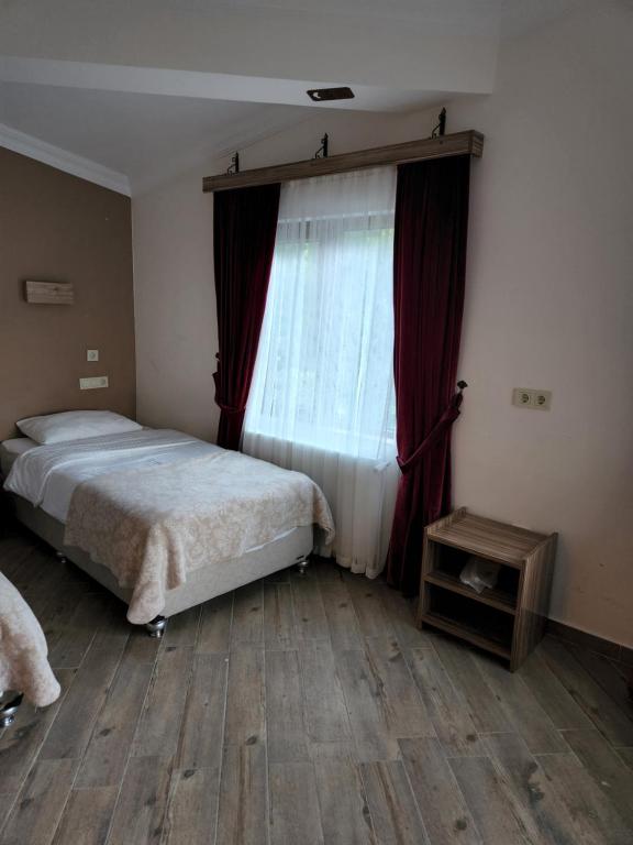 A bed or beds in a room at Mersu A'la Konak Otel