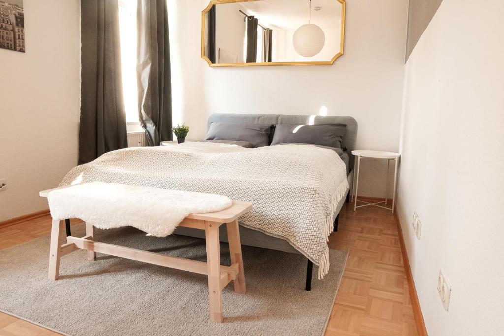 a bedroom with a bed with a table and a mirror at FullHouse - Halle - AB7 Apartments - City Center in Halle an der Saale