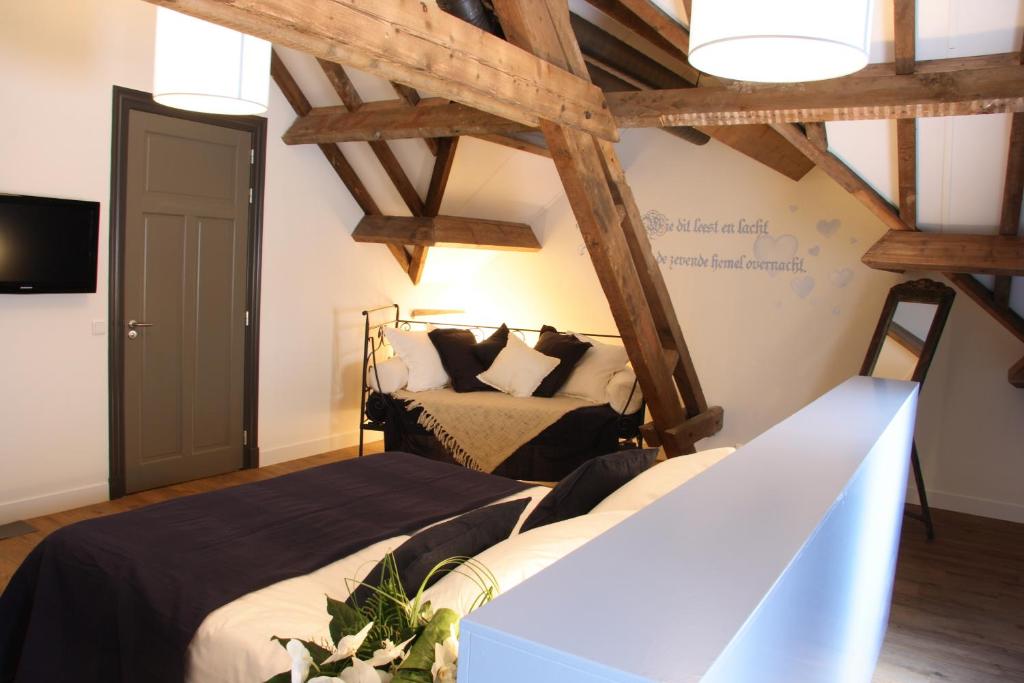 a bedroom with two beds in a room with wooden beams at Herberg de Brabantse Kluis in Aarle-Rixtel