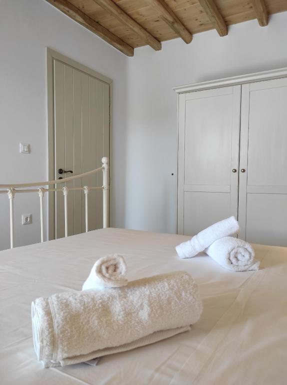 Un dormitorio blanco con una cama con toallas. en Traditional suites in Chora Kythnos #3, en Kithnos