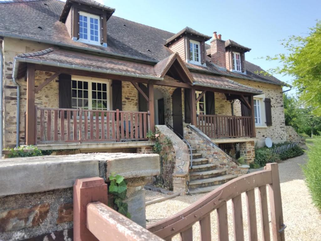 a house with a wooden fence in front of it at Ground floor stylish french holiday home in Arnac-Pompadour