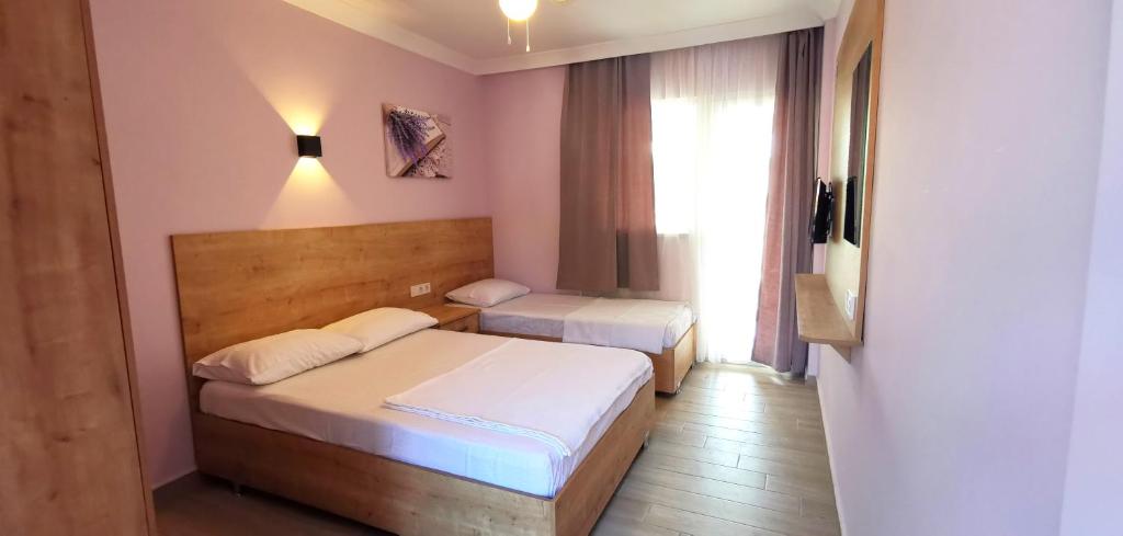 een slaapkamer met 2 bedden en een raam bij Motel Lavanda in Avsa Adasi