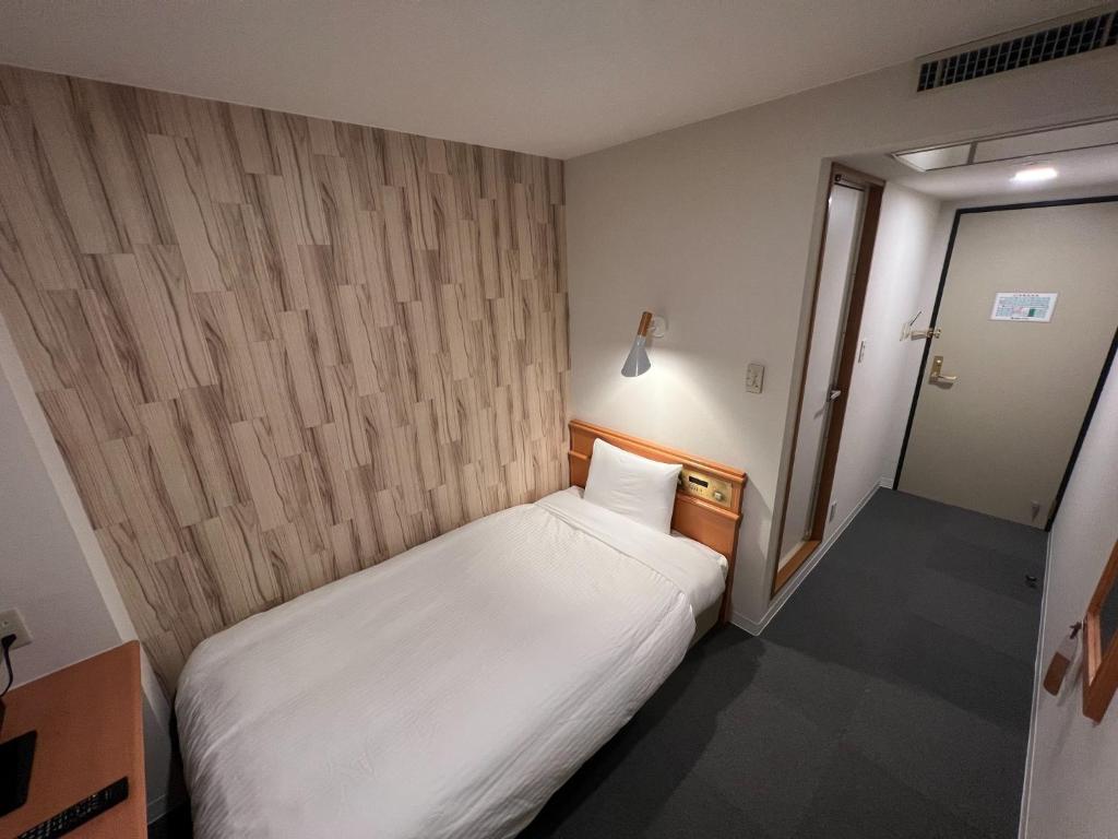 a small bedroom with a white bed in it at Kitami Daiichi Hotel - Vacation STAY 45969v in Kitami