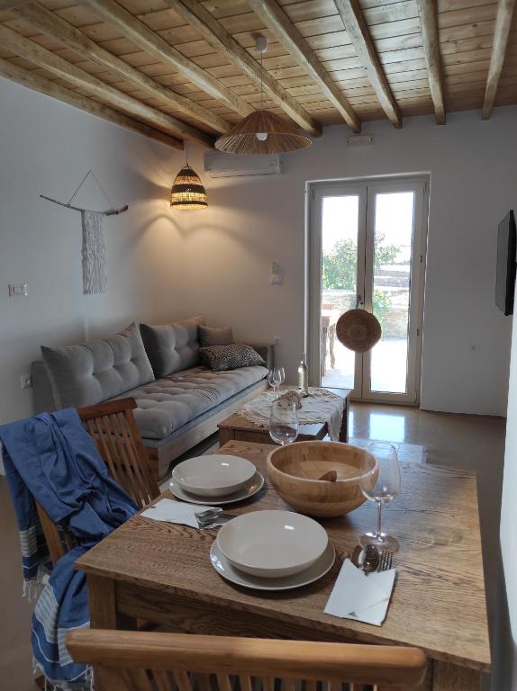 uma sala de estar com uma mesa e um sofá em Traditional suites in Chora Kythnos #5 em Kythnos