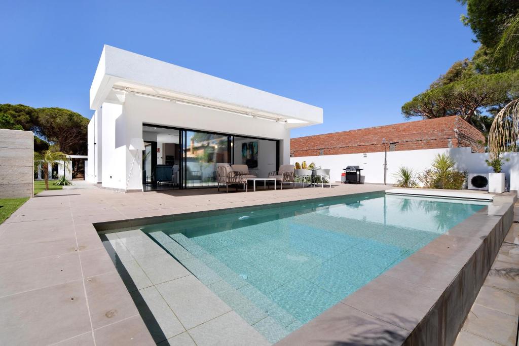 a swimming pool in front of a house at Maria del Mar Sea Villa in Novo Sancti Petri