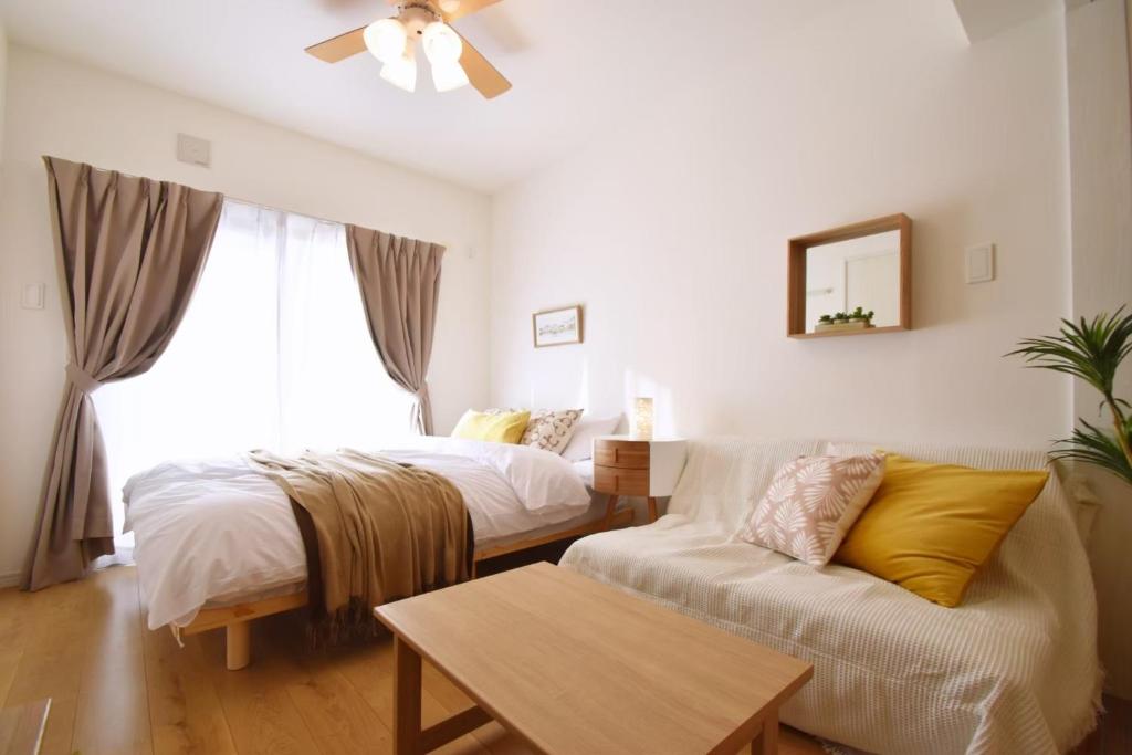 - un salon avec deux lits et un canapé dans l'établissement Mishku onna - Vacation STAY 88056v, à Baba
