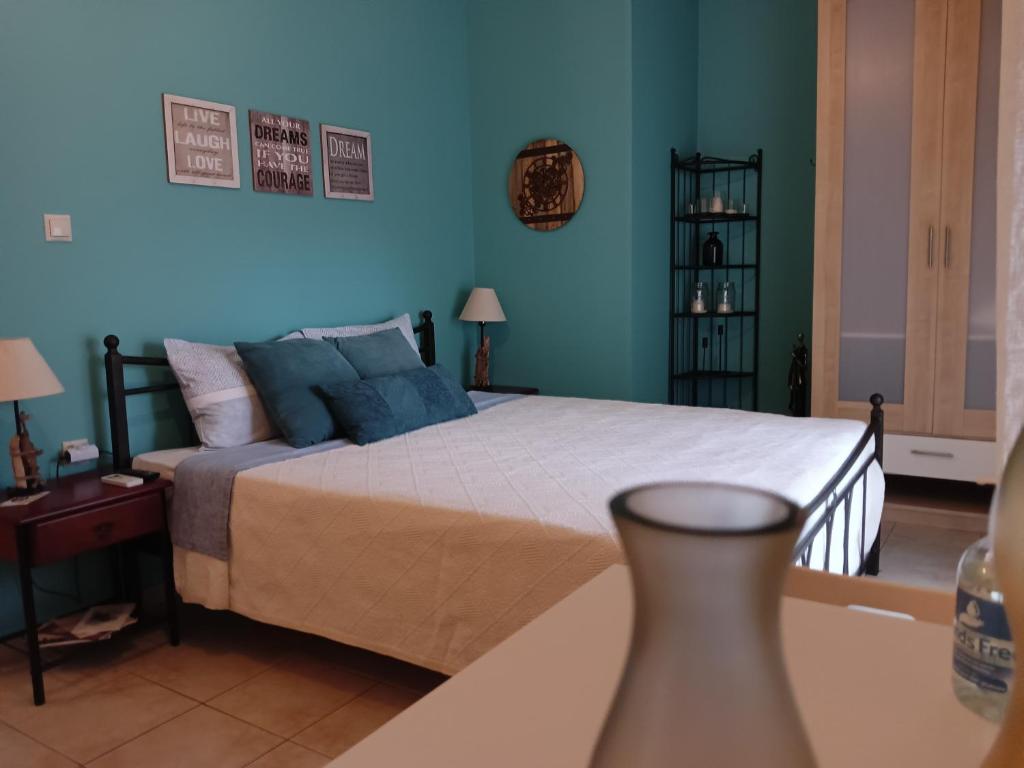- une chambre avec un grand lit aux murs bleus dans l'établissement Amelie's Apartments, à Mesolongion