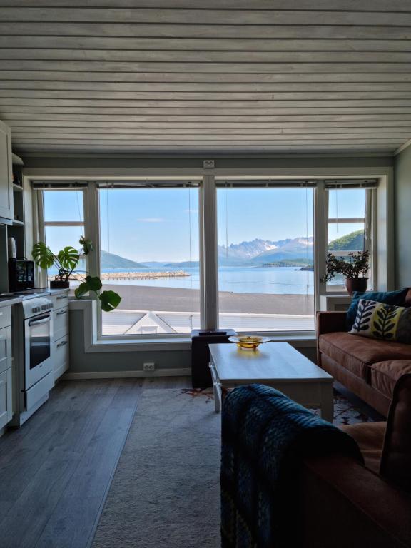 a living room with a view of the ocean at Loftsleilighet midt i sentrum in Skjervøy