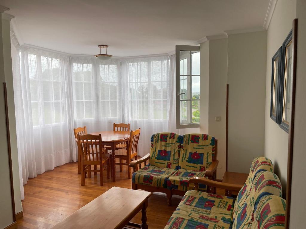 salon ze stołem i krzesłami w obiekcie Ermita San Vicente de la Barquera Duplex w mieście San Vicente de la Barquera