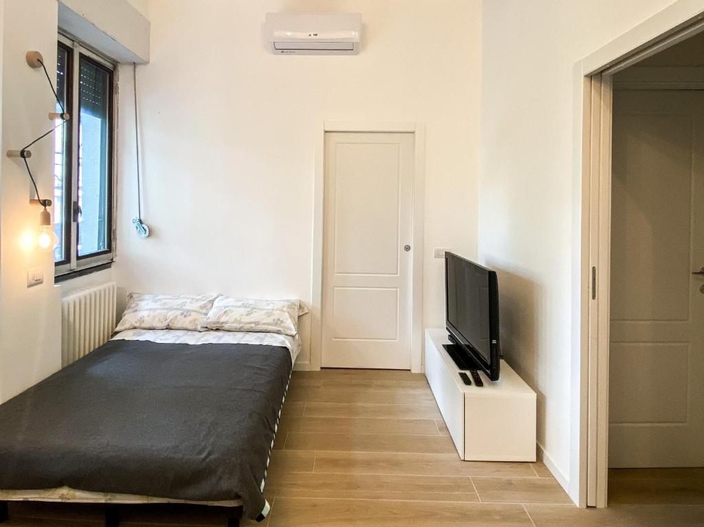 - une chambre avec un lit et une télévision à écran plat dans l'établissement Molino cozy apartment with park view in downtown Milano, à Milan