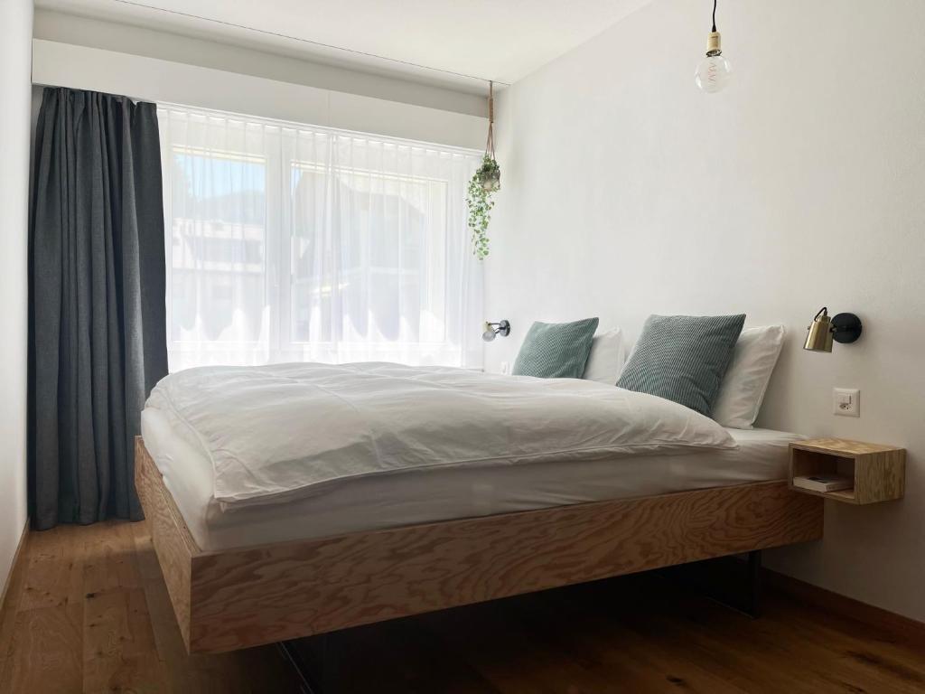 a bedroom with a large bed with a window at Haus Allod 208 in Lenzerheide