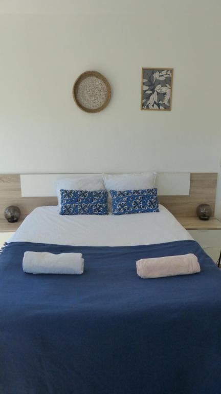 a large blue bed with two towels on it at Cocon d EMERAUDE et de SAPHIRE à Antony in Antony