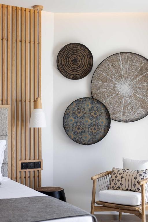 a bedroom with plates on the wall and a chair at Atlantica Bay - Adults Only in Limassol