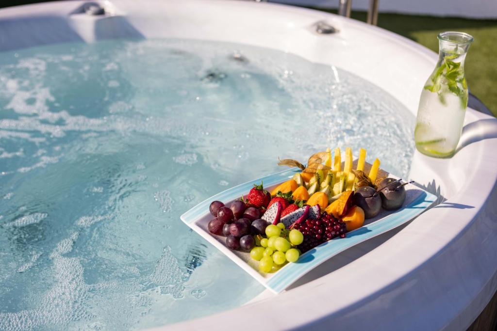 a tray of fruit sitting on top of a swimming pool at Atlantica Bay - Adults Only in Limassol