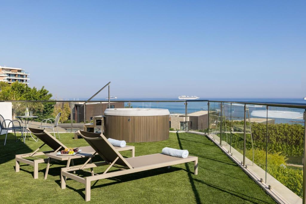 a patio with two chairs and a table on the grass at Atlantica Bay - Adults Only in Limassol