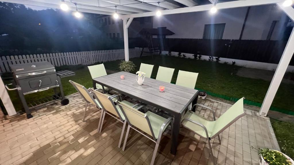 - une table et des chaises en bois sur une terrasse avec barbecue dans l'établissement B&B Home, à Sighişoara